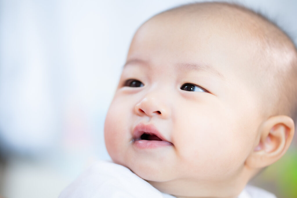 Asian baby happy in the room.Asian baby girl lying down on bed .